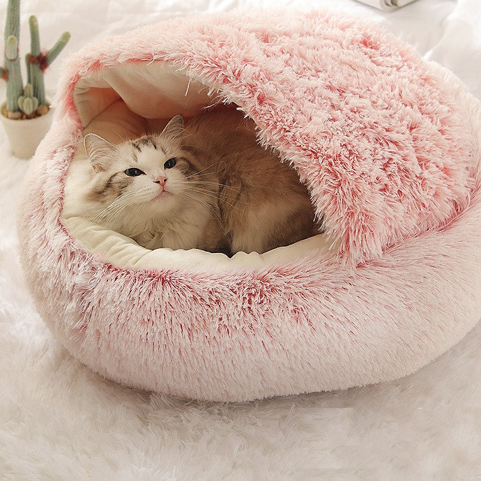 Gato dentro de la cama nido rosa con capota